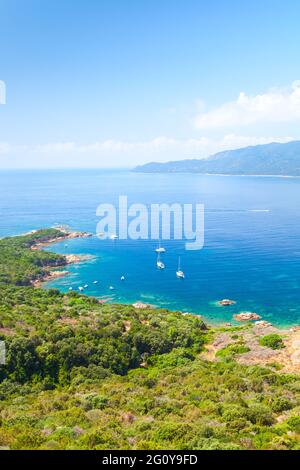 Isola di Corsica, Golfo di Cuarabia. Paesaggio estivo con barche a motore di piacere ormeggiate vicino spiaggia di costa rocciosa Foto Stock