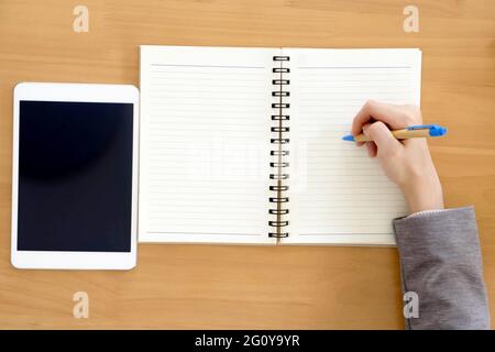 Donna d'affari che scrive nel suo notebook che pianifica qualcosa. Foto Stock