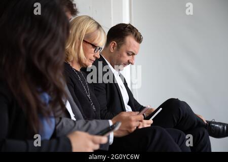 Gruppo di businesswoman senior e uomo d'affari utilizzando smartphone per lo shopping online o concetto di e-commerce Foto Stock