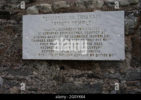 Cartello al Teampull Na Trianaid Trinity Temple, North Uist, Outer Hebrides, Scotland. Spiega la storia del tempio. Cartello resistente alle intemperie isolato su muro di pietra. Foto Stock