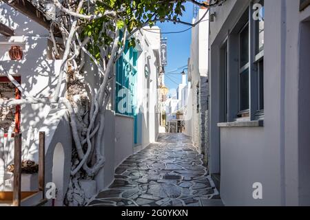 Chora, isola di Kythnos, Cicladi, Grecia. 16 maggio 2021. Edifici tradizionali imbiancati di bianco sotto lo sfondo del cielo blu chiaro greco. Caffè taverna tavoli cha Foto Stock