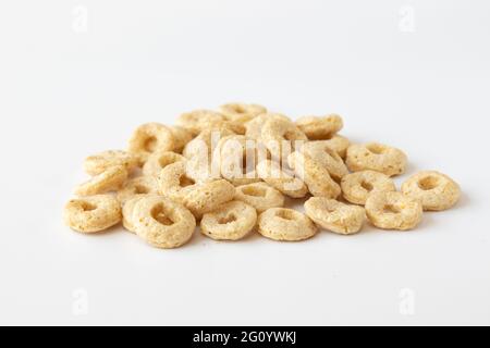 mucchio di cereali cheerios isolato su sfondo bianco, deliziosi e utili anelli colazione cereali, vista laterale primo piano Foto Stock