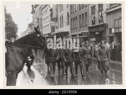 Arrivo Oberbefehlshaber der Wehrmacht F. Christiansen; NSB. Il generale Der Flieger e Oberbefehlshaber der Wehrmacht Friedrich Christiansen (terzo da sinistra) arrivano all'aia sulle lunghe gambe in compagnia di alcuni alti ufficiali tedeschi. Ha lasciato la testa di un cavallo. Rimase comandante della Wehrmacht nei Paesi Bassi durante la guerra. Fu anche colui che ordinò la Razzia a Putten nel 1944. Foto Stock