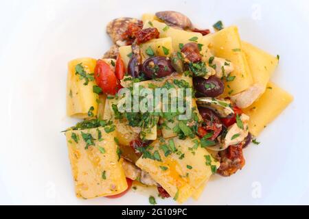 Cucina italiana: Paccheri con fette di pesce spada, olive e vongole Foto Stock