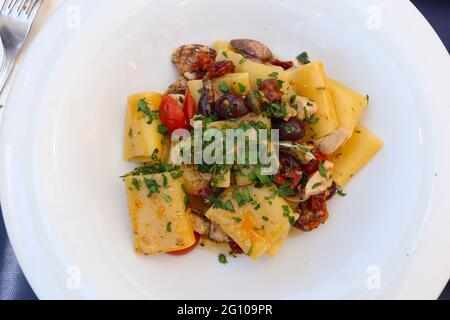 Cucina italiana: Paccheri con fette di pesce spada, olive e vongole Foto Stock