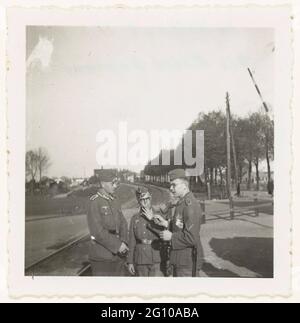 Soldati di Wehrmacht in una stazione. Tre soldati della Wehrmacht si trovano su una linea ferroviaria, dietro di loro alberi ferroviari. Il mezzo fuma una sigaretta. Possono essere alla stazione di Dordrecht (vedi NG-2007-5-120). Diritto di esso: In Olanda. 15.5.41. Che ha viaggiato. Foto Stock
