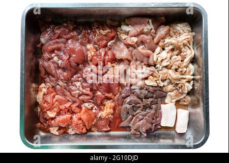 Varie parti di maiale crudo affettato con maiale marinato, pancia di maiale, fegato di maiale su vassoio in stalla Foto Stock