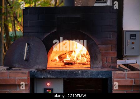 Legna da ardere in tradizionale stufa da pizza in pizzeria Foto Stock