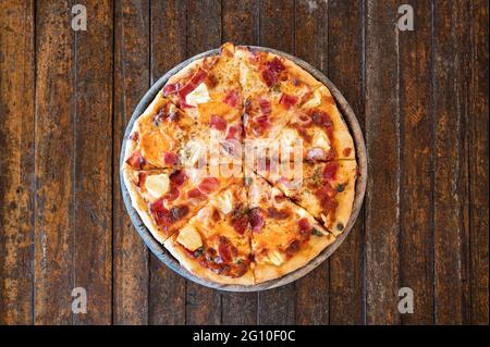 Pizza al barbecue con pancetta hawaiana affumicata fatta in casa su vassoio di legno Foto Stock
