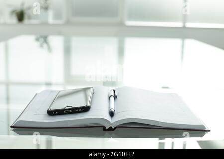 Telefono diario penna su tavolo di vetro Foto Stock