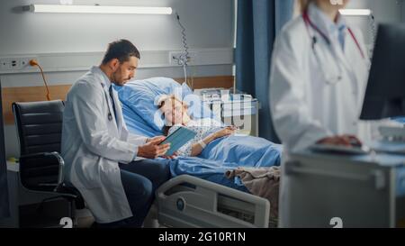 Hospital Ward: Medico femminile professionale utilizza un computer medico. In background chirurgo Clinic attrezzature moderne utilizzando Tablet computer Consulting Foto Stock