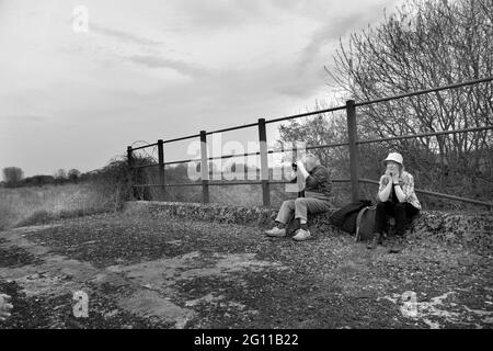 uomo e donna seduti sul vecchio ponte ferroviario ridondante ellingham norfolk inghilterra Foto Stock
