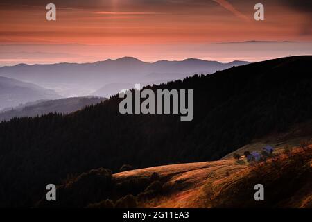 Tramonto arancione sulla montagna dei Vosgi in Francia con vista su un rifugio in quota Foto Stock