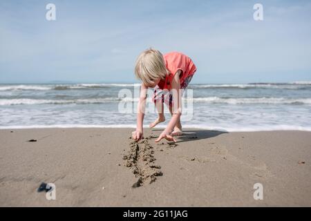 USA, California, Ventura, Boy che giocano sulla spiaggia Foto Stock