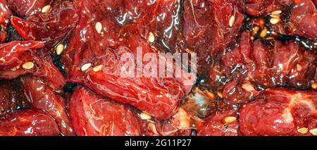 Fette di manzo marinate, luminose e succose, con spezie, olio e semi di sesamo Foto Stock