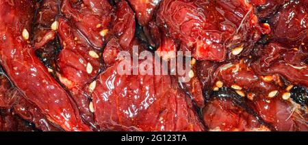 Fette di manzo marinate, luminose e succose, con spezie, olio e semi di sesamo Foto Stock