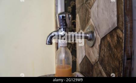 Rubinetto d'acqua moderno chiuso o rubinetto all'esterno del bagno. Igienizzatore per le mani e rubinetto dell'acqua. Foto Stock