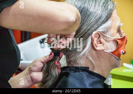 Miami Florida,anziani anziani anziani anziani cittadini pensionati pensionati anziani pensionati anziani pensionati, uomo uomini maschio adulti, maschio donando capelli lunghi taglio,fatto in Foto Stock