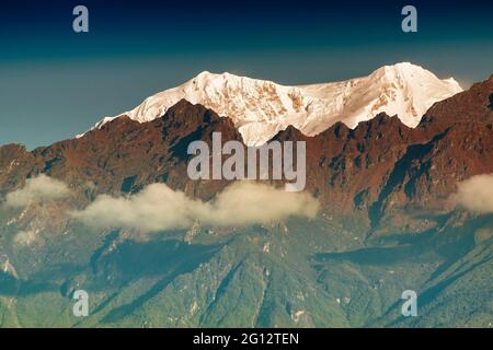 Bella prima luce dall'alba sul Monte Kanchenjugha, catena montuosa dell'Himalaya, Sikkim, India. Tinta arancione sulle montagne all'alba Foto Stock