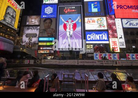 OSAKA, GIAPPONE - 24 dicembre 2019: Osaka, Giappone - 28 novembre 2019: Il tabellone pubblicitario di Glico Man e altri annunci pubblicitari a Dontonbori, Osaka. Foto Stock