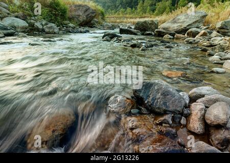 Bella acqua del fiume Reshi che scorre su rocce all'alba, Sikkim, India - una vista spettacolare, immagine colorata Foto Stock