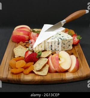 Formaggio e cracker esposti su un pannello di legno Foto Stock