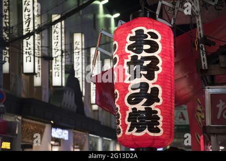 OSAKA, GIAPPONE - 26 dicembre 2019: Osaka, Giappone - 28 novembre 2019: Parola Okonomiyaki, pancake saporito scritto in giapponese sulla lanterna rossa. Foto Stock