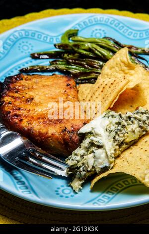 Costolette di maiale marinate alla griglia con fagioli verdi e salsa di spinaci carciofi Foto Stock