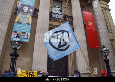 Londra, Regno Unito. 4 Giugno 2021. Un attivista detiene una bandiera della ribellione estinzione fuori dalla Commissione Canadese in Trafalgar Square. Gli attivisti si sono riuniti per protestare contro l'esplorazione petrolifera nella regione africana di Okavango da parte della compagnia canadese ReconAfrica, produttrice di petrolio e gas. (Credit: Vuk Valcic / Alamy Live News) Foto Stock