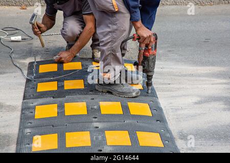 I lavoratori della strada che mettono dossi di velocità in Bosnia-Erzegovina Foto Stock