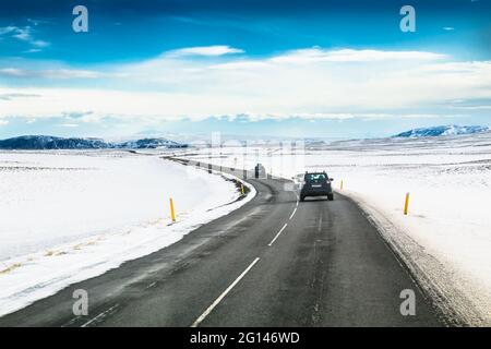 Islanda viaggio su strada, l'autostrada lungo le montagne coperte di neve, incredibile paesaggio islandese, pittoresca vista invernale, la notte si sposta a un tramonto Foto Stock