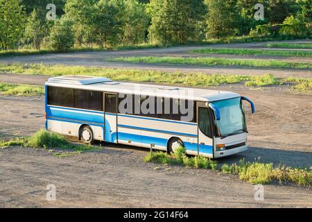 L'autobus si trova in un campo su una strada sterrata. Bus nel mezzo del campo. Sfondo con posizione per il testo Foto Stock