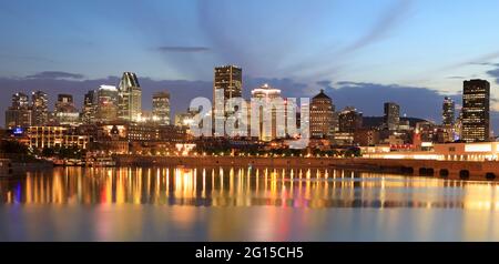 Skyline di Montreal al tramonto con riflessi di luci sul fiume St Lawrence a Quebec, Canada Foto Stock