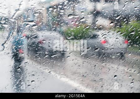 Pioggia sul parabrezza dall'interno dell'auto in ingorgo Foto Stock