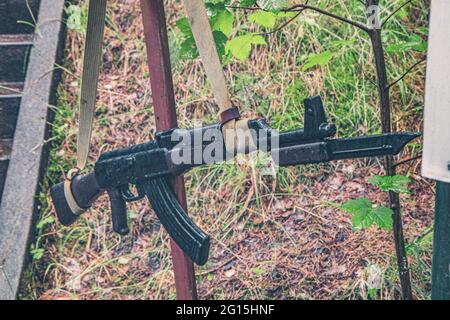 AK-47 Kalashnikov e granate si accodano nella foresta della penisola di Hel in Polonia. Girato dopo una doccia a pioggia in estate in un bunker. Foto Stock