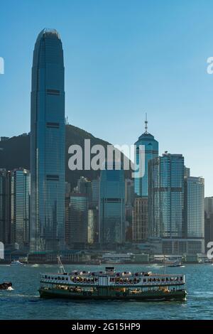 Un iconico Star Ferry attraversa Victoria Harbour di fronte al 2ifc e gli alti edifici del centro, l'isola di Hong Kong Foto Stock