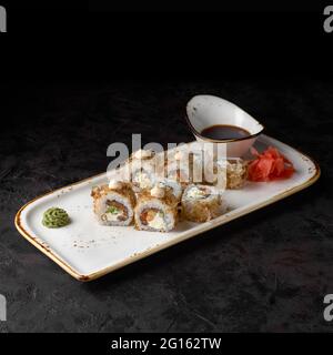 Sushi Bonito. Arrotolare con formaggio, cetriolo, salmone e fiocchi di tonno su uno sfondo nero testurizzato. Menu sushi. Cibo giapponese. Foto Stock
