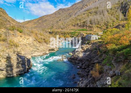 Il fiume Kawarau nella regione di Otago, Isola del Sud, Nuova Zelanda. Sulla destra si trova la centrale idroelettrica Roaring Meg Foto Stock