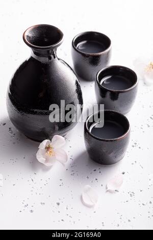 Sake giapponese in ceramica nera. Sake tradizionalmente servito in  ceramica. Ceramica nera su una pietra bianca Foto stock - Alamy