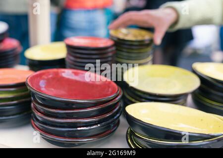 Alto stack di lastre in ceramica di diverse dimensioni, texture e colors.at fondo sono sfere di vetro di colore rosso e giallo, dietro tinsel.Horizontal Foto Stock