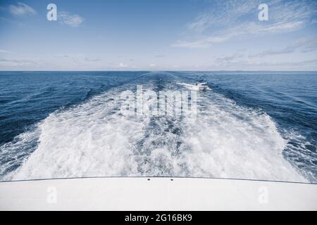 Vista dalla poppa della barca dell'effetto wake (wash) sull'acqua dal motore posto sullo specchio di una lussuosa nave da safari che naviga tra Maldiv Foto Stock