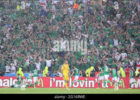 LIONE, FRANCIA - 16 GIUGNO 2016: I tifosi irlandesi sulle tribune dello stadio Stade de Lyon festeggiano dopo che i loro giocatori hanno segnato un gol durante la partita UEFA EURO 2016 Ucraina contro Irlanda del Nord. N.Ireland ha vinto il 2-0 Foto Stock