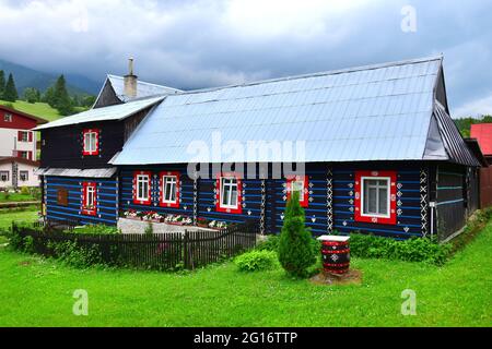 Una bella piccola casa di legno nella piccola città di Zdiar, vicino agli alti Tatra, Slovacchia. Immagine presa da terra pubblica. Foto Stock