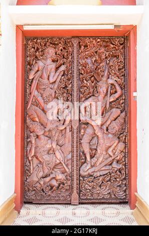 Figure scolpite in porta a Wat Luang Pakse, tempio di Pakse, Laos Foto Stock