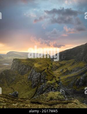 Solo donna escursionista sul picco di Quiraing durante il tramonto drammatico Foto Stock