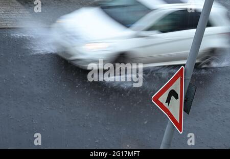 05 giugno 2021, Hessen, Francoforte sul meno: Un'auto si trova in una strada nel quartiere Sachsenhausen durante la pioggia battente. (Scatto con velocità dell'otturatore più lenta) Foto: Arne Dedert/dpa Foto Stock