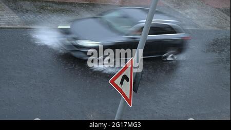 05 giugno 2021, Hessen, Francoforte sul meno: Un'auto si trova in una strada nel quartiere Sachsenhausen durante la pioggia battente. (Scatto con velocità dell'otturatore più lenta) Foto: Arne Dedert/dpa Foto Stock