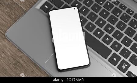 Mockup di un telefono cellulare su una tastiera di un computer portatile. È possibile posizionare il progetto sullo schermo. Ideale per presentare progetti o applicazioni Web. Foto Stock