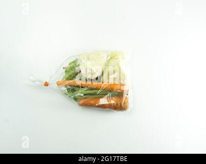Ingredienti per zuppe di verdure avvolti in plastica trasparente trasparente. Foto Stock
