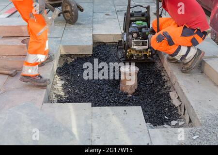 i lavoratori posano blocchi di cemento nella zona pedonale Foto Stock